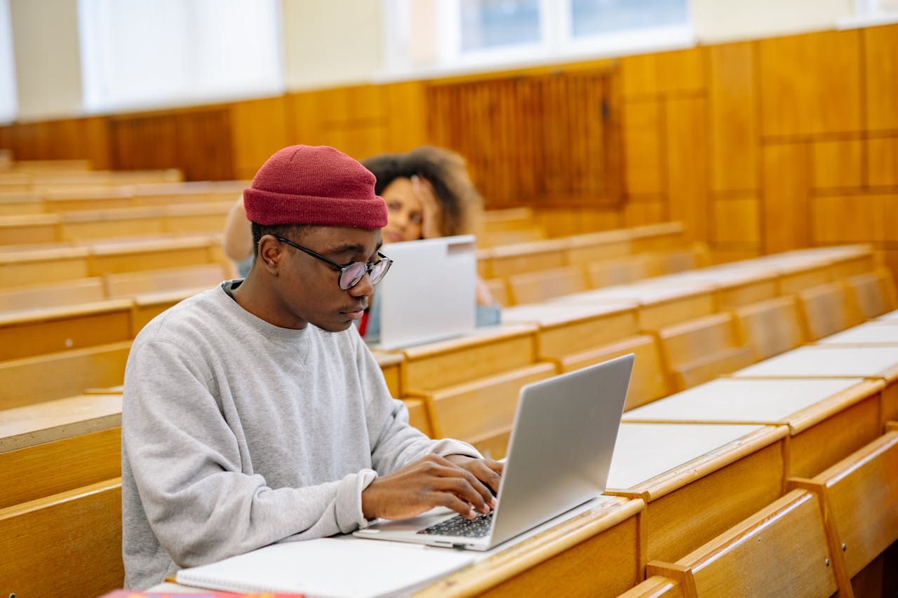 embark Students focus on laptops in a spacious university lecture hall, learning and working digitally.